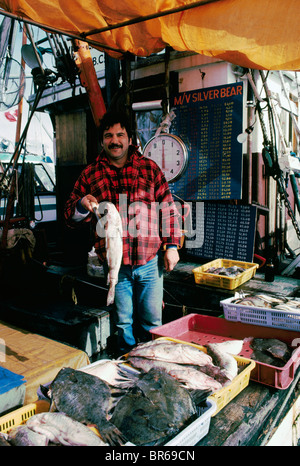 Steveston, BC, British Columbia, Canada - pescatore con pesce in vendita su commerciale pesca barca ormeggiata al mercato Foto Stock