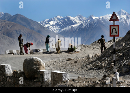 Operai riparare la strada per il Khardung La pass, ha affermato di essere la più alta strada motorable nel mondo, in Ladakh, India. Foto Stock