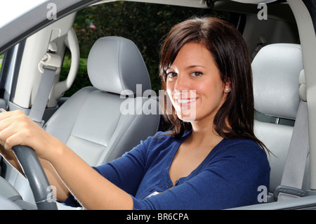 Donna attraente Conducente seduto nel sedile del conducente di un veicolo per la famiglia Foto Stock