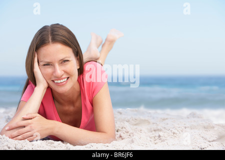 Giovane donna rilassante sulla spiaggia sabbiosa Foto Stock