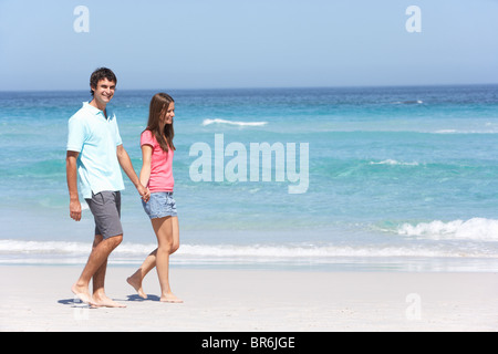 Coppia in vacanza a piedi lungo la spiaggia di sabbia Foto Stock