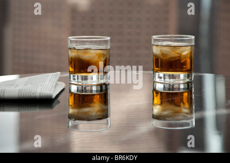 Due bicchieri di whiskey e ghiaccio su un tavolo Foto Stock