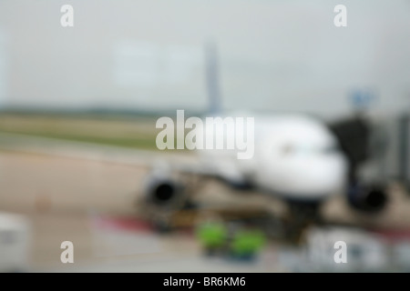 Un piano su un aeroporto tarmac, sfocato Foto Stock