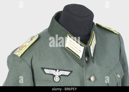 Un ensemble uniforme per un ispettore postale di campo., una tunica gabardina grigia di campo con collare verde scuro (falle di falena), aquila pettorina ricamata in argento e anelli di medaglia. Le chiazze da collare e gli spalline hanno una tubazione gialla di limone, le spalline hanno un cordone giallo e visualizzano le lettere 'FP'. Nessun bracciale. Un soprabito in lana grigio con colletto verde scuro, supplicine e francobolli di dimensioni nel rivestimento, e spalline cucite come la tunica. Braghe di gabardine grigio pietra con cinghie per le gambe e finiture in pelle. Sacco da campo bloccabile con una fessura di deposito posta, recante il , Foto Stock