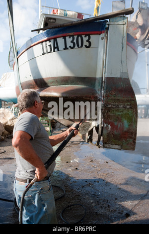 Lavoratore barca pulizia con acqua ad alta pressione in cantiere Formia Campania Italia Foto Stock