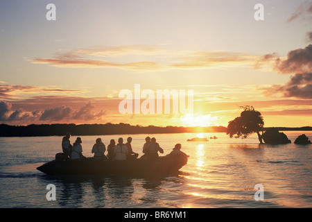 I turisti in barca Zodiac al tramonto, laguna centrale, isola di Aldabra, Seychelles, Oceano Indiano Foto Stock