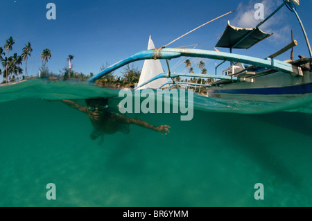 A livello diviso vista del subacqueo in tradizionali outrigger banca barca da pesca, Filippine Foto Stock