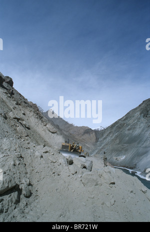 Bulldozer di eliminare i detriti sulla strada nuova in Zanskar fiume valle del Ladakh. Foto Stock