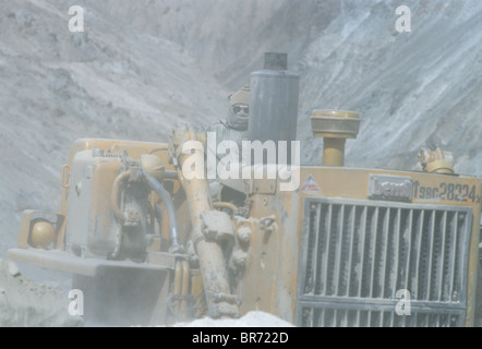 Bulldozer di eliminare i detriti sulla strada nuova in Zanskar fiume valle del Ladakh. Foto Stock