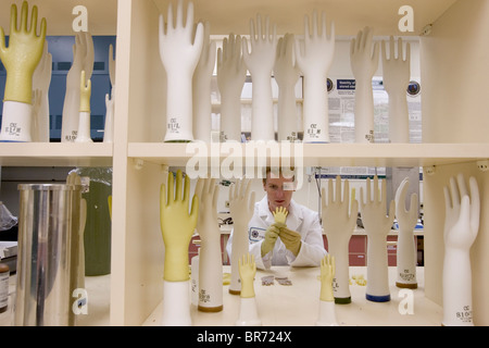 Scienziato con la Yulex Corp. rende i prototipi dei guanti di gomma per testare diverse formulazioni di lattice guayule Foto Stock