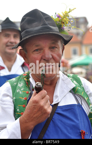 Uomo con tubo in costumi folk sul festival di uva harves Foto Stock