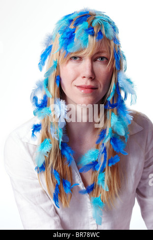 Giovane donna con piume nei capelli Foto Stock