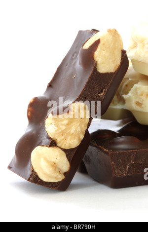 Dark e cioccolato bianco con nocciole intere close up su sfondo bianco Foto Stock