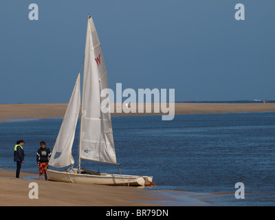 Coppia con barche a vela sulla sabbia, Padstow Beach, Cornwall, Regno Unito Foto Stock