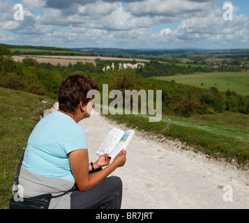 La donna la lettura di una guida a piedi sulla mappa della South Downs. Foto Stock