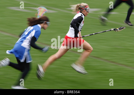 Una Università cattolica player in attacco come un Marymount University giocatore insegue durante un college lacrosse gioco 11 Aprile 2007 Foto Stock