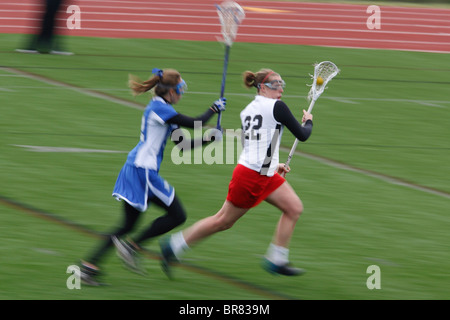 Una Università cattolica player in attacco come un Marymount University giocatore insegue durante un college lacrosse gioco 11 Aprile 2007 Foto Stock