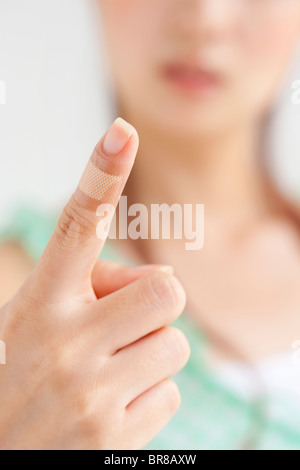 Donna di dito con bendaggio, close up, la messa a fuoco del differenziale Foto Stock