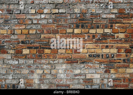 In rosso di un muro di mattoni che è visto giorni migliori. Foto Stock
