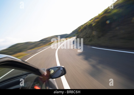 Una macchina in esecuzione su strada tortuosa in montagna Foto Stock