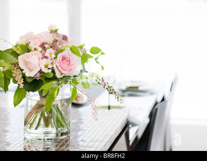 Un mazzo di fiori in un vaso al tavolo da pranzo Foto Stock