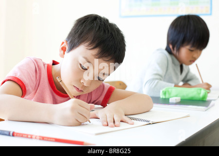 I ragazzi che studiano a scuola cram Foto Stock