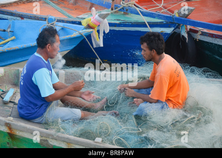 I pescatori riassettavano le reti al porto da pesca in Hua Hin Tailandia Foto Stock