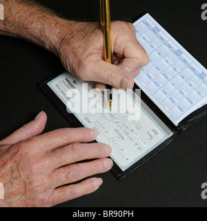 Anziani mans mani scrivendo una decina di migliaia di dollari di controllo indipendente dalla Banca nazionale Florida USA Foto Stock