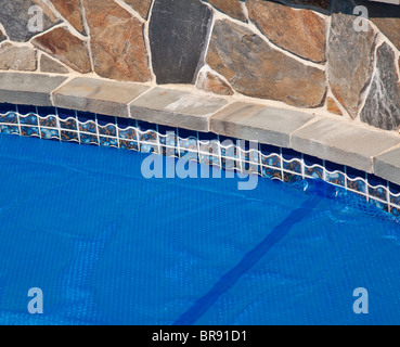 Piscina interna Piscina con solare blu Bubble wrap coperchio per mantenere il calore dell'acqua Foto Stock