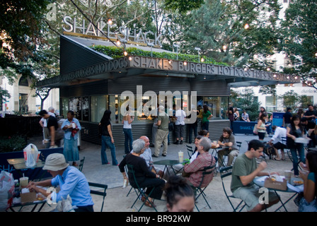 Persone sedersi a tavoli attorno un ristorante chiosco in Madison Square Park di New York City New York. Foto Stock