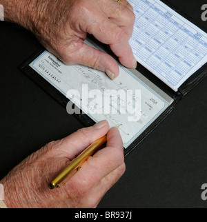 Anziani mans mani scrivendo una decina di migliaia di dollari di controllo indipendente dalla Banca nazionale Florida USA Foto Stock