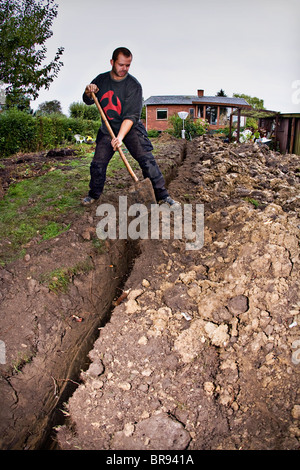 I tubi per il riscaldamento geotermico sistema essendo scavato nel giardino Foto Stock