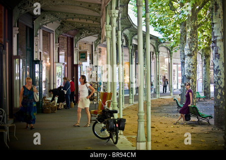 I turisti di passeggiare attraverso la forma a ferro di cavallo shopping arcade, in Vichy ( shoppers shopper). Foto Stock