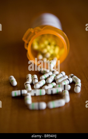 Le capsule di farmaco riversando fuori della bottiglia di prescrizione, bianco e nero, farmaco prozac medicina medicinale Foto Stock