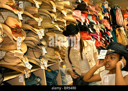 Una giovane ragazza cerca su un cappello da cowboy in Chicago Foto Stock