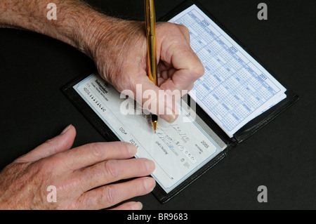 Anziani mans mani scrivendo una decina di migliaia di dollari di controllo indipendente dalla Banca nazionale Florida USA Foto Stock