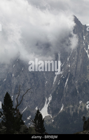 Rising nebbia nube bassa volute intorno Els Encantats peak vista da d'Amitges in Sant Maurici Parco Nazionale Pirenei Spagna Foto Stock