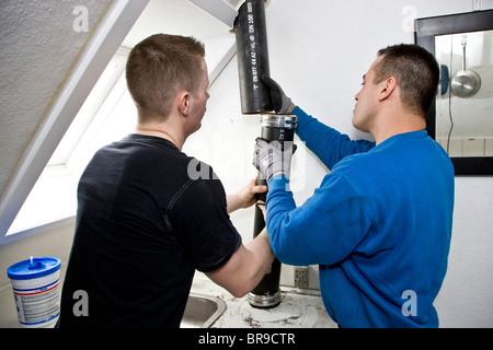 Due gli idraulici sostituire il vecchio leaky gronde con nuove tubazioni Foto Stock