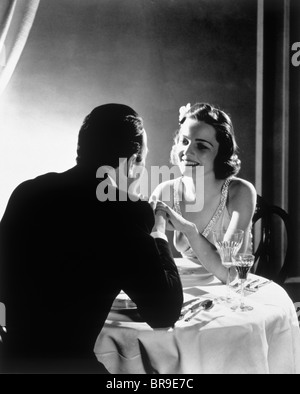 1930s coppia romantica uomo donna elegante tavolo da pranzo Foto Stock