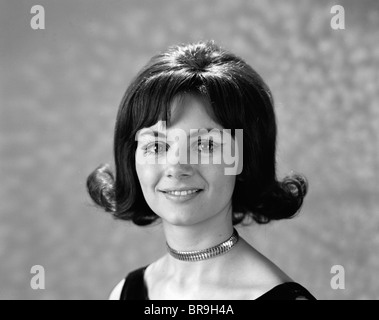 Anni sessanta anni settanta ritratto sorridente BRUNETTE DONNA FLIP CAPELLI STILE CON BANGS GUARDANDO LA TELECAMERA Foto Stock