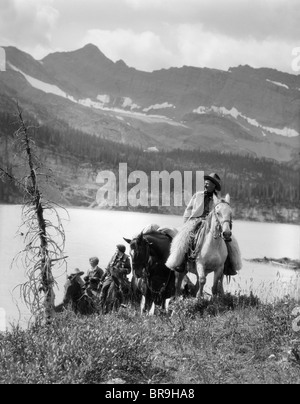 Anni Venti anni trenta due donne un uomo a cavallo western selle cowboy di lana che indossa CHAPS DAL LAGO DI MONTAGNA IN CANADA Foto Stock