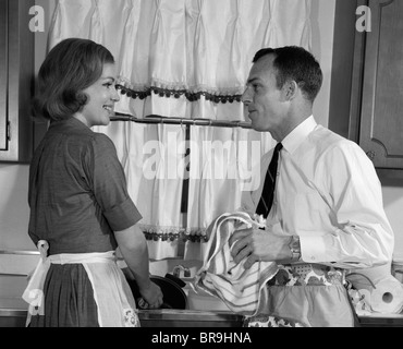 Anni sessanta uomo donna lavaggio piatti lavello da cucina Foto Stock