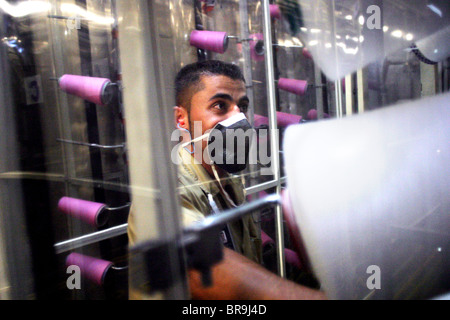 Un lavoratore controlli rocchetti di filato in una fabbrica tessile al di fuori della città di Medellin. Foto Stock