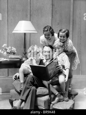 1930s padre la lettura per la famiglia in cattedra Foto Stock