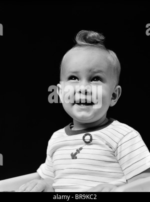 1940s sorridente ragazzo biondo con grande ricciolo sulla sommità della testa cercando Foto Stock