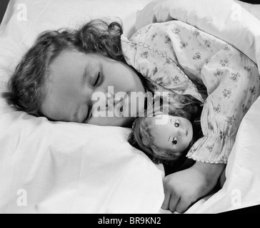 Anni Cinquanta bambino bambina dormire nel letto con bambola Foto Stock