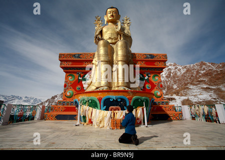 Una donna è pregare presso il golden Meitraya Buddha a monastero Likir Ladakh,l'India Foto Stock