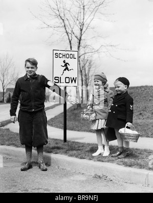 Negli anni Trenta due bambini ragazza ragazzo in attesa di Cross Street attraversamento GUARD Foto Stock