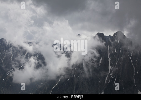 Rising nebbia nube bassa volute intorno Els Encantats peak vista da d'Amitges in Sant Maurici Parco Nazionale Pirenei Spagna Foto Stock