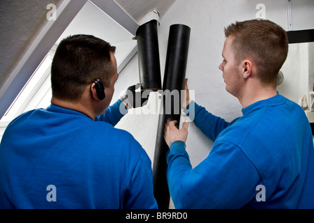 Due gli idraulici sostituire il vecchio leaky gronde con nuove tubazioni Foto Stock